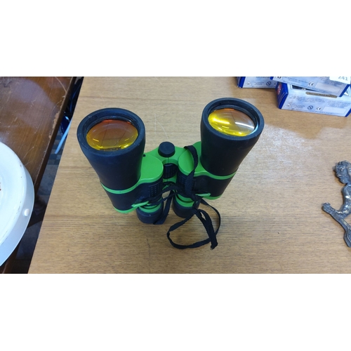 242 - Green and black binoculars with adjustable central focus and strap. Enhanced with yellow-tinted lens... 