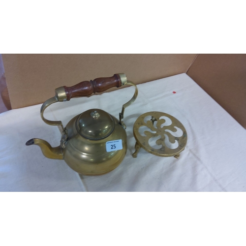 25 - Victorian brass kettle with a wooden handle, includes a matching brass trivet.