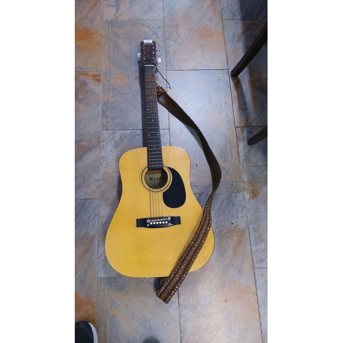 258 - Kyoto acoustic guitar with a natural wood finish, six strings, and adjustable brown strap. Brand log... 
