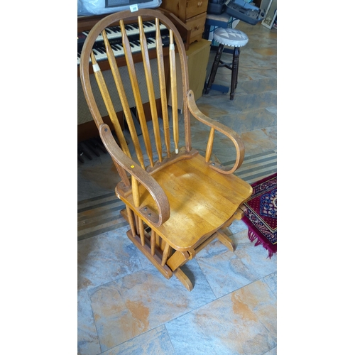 288 - Vintage wooden spindle-back rocking chair with curved armrests. Crafted from polished oak, featuring... 