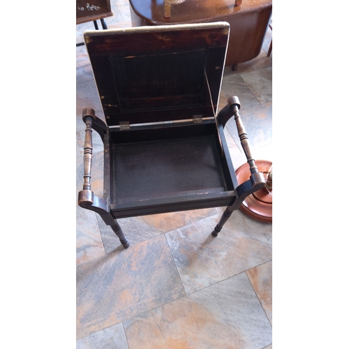 290 - Victorian-era wooden piano stool with upholstered seat and internal storage compartment. It features... 