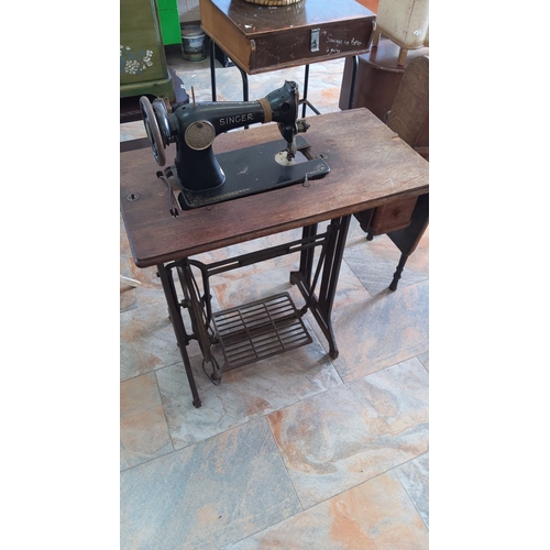 291 - Antique Singer treadle sewing machine with wooden cover, featuring intricate cast iron base and oak ... 