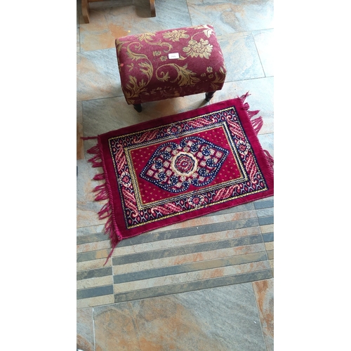 295 - Ottoman with floral tapestry upholstery. Small Persian-style fringed rug in rich red, blue, and gold... 