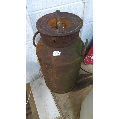 370 - Vintage metal milk churn with rusted exterior and side handles, approximately 3 feet tall.