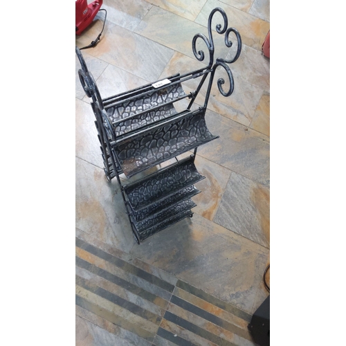 381 - Ornate wrought iron magazine rack with several tiers. It features intricate scrollwork details and e... 