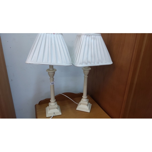 412 - Pair of cream-colored table lamps with pleated shades, featuring classic column bases.