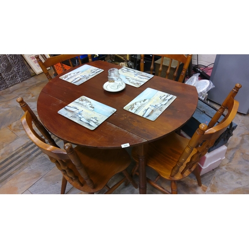 422 - Round wooden dining table with four matching spindle-back chairs.