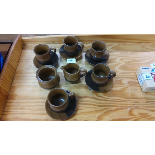 440 - Set of six brown pottery teacups with matching saucers and a cream jug. Simple, elegant design.