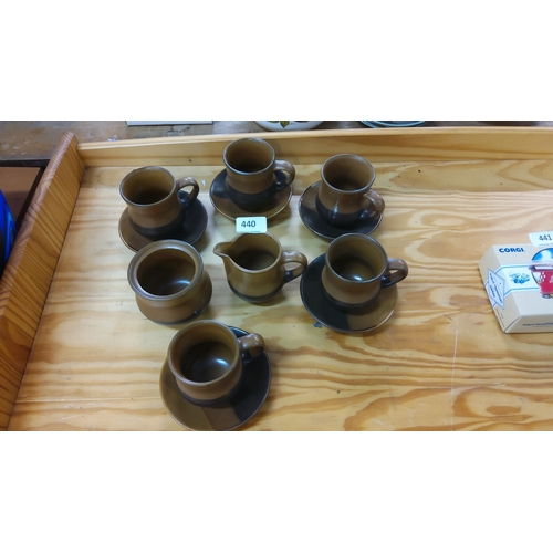 440 - Set of six brown pottery teacups with matching saucers and a cream jug. Simple, elegant design.