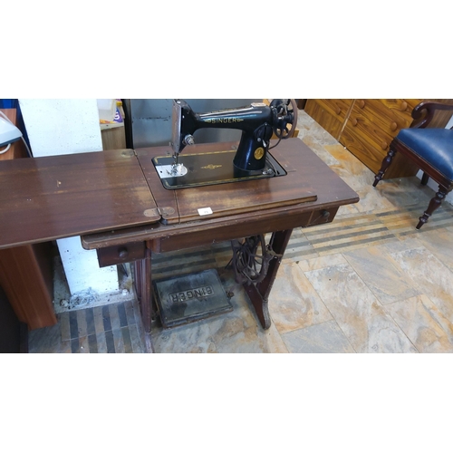 79 - Singer treadle sewing machine with oak wood table, early 20th century. Features a classic black lacq... 