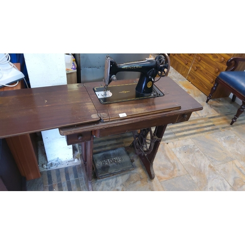 79 - Singer treadle sewing machine with oak wood table, early 20th century. Features a classic black lacq... 