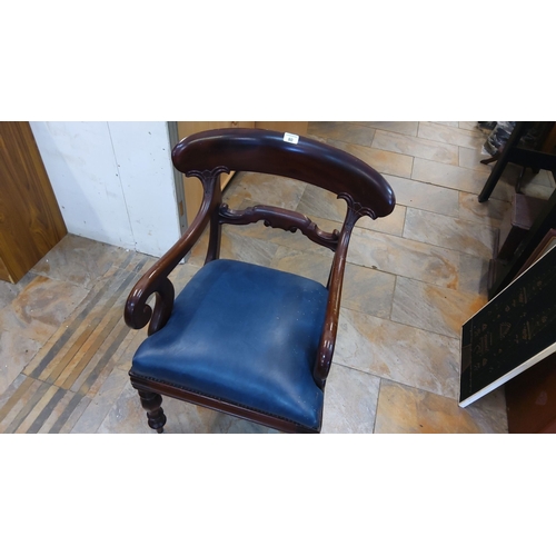 80 - Victorian-style mahogany armchair with carved backrest and scrolled arms, featuring a blue upholster... 