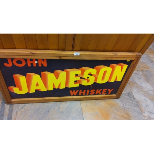 82 - Vintage Tin John Jameson Whiskey advertising framed sign. Features vibrant yellow and red text on a ... 