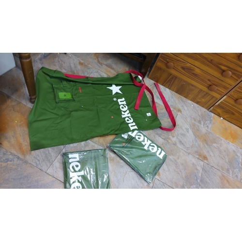 84 - Set of three green Heineken aprons with red ties. Features logo and star. Two aprons are in original... 