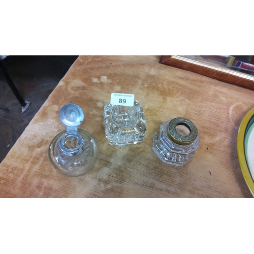 89 - Set of three vintage glass inkwells with intricate designs and metal lids.