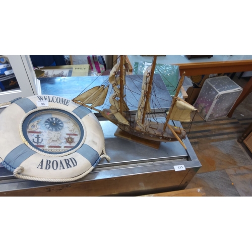94 - Nautical decor lot consisting of a wooden sailing ship model and a nautical-themed clock housed in a... 