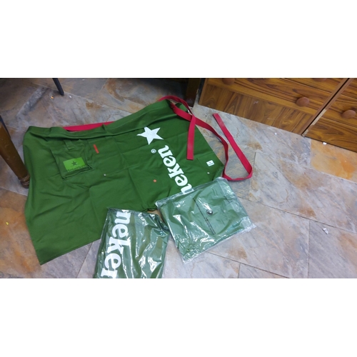 98 - Set of 3 green Heineken aprons with red straps, including two packaged aprons. These aprons are bran... 