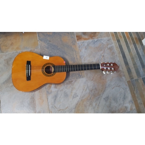 31 - Acoustic classical guitar with a natural wood finish, traditional design, and nylon strings.