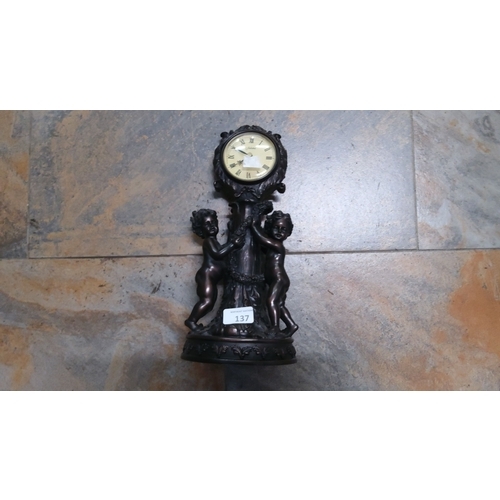 137 - Juliana mantle clock with cherub figures and Roman numeral dial