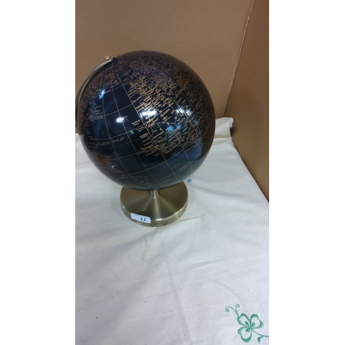 11 - Black world globe with gold detailing, set on a brass-colored base.