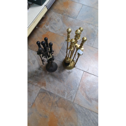 132 - Pair of fireplace tool sets, one brass and one wrought iron. Both sets include shovels, tongs, and p... 