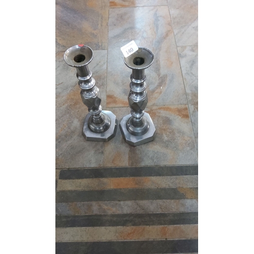 140 - Pair of vintage silver-plated candle holders with octagonal bases and decorative columns.