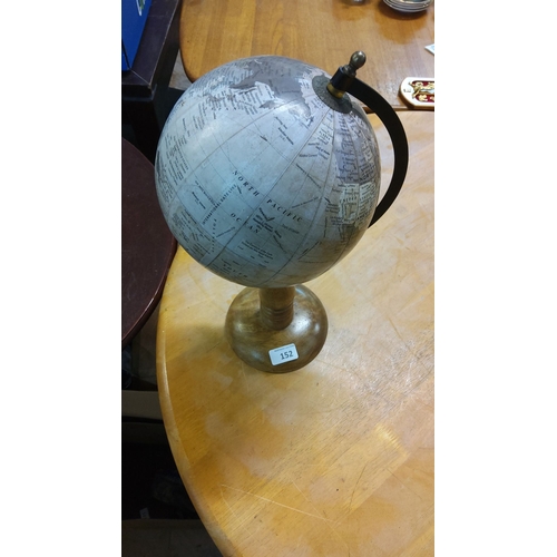 152 - Vintage tabletop globe on a wooden stand, featuring detailed geographical markings.