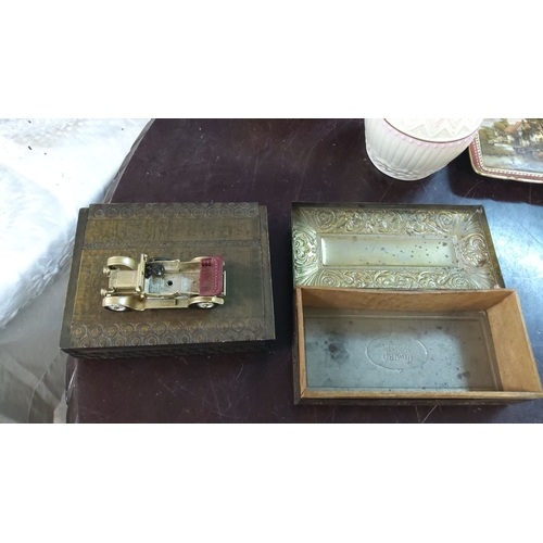 169 - Two intricately embossed metal boxes. One box features a vintage toy car atop.