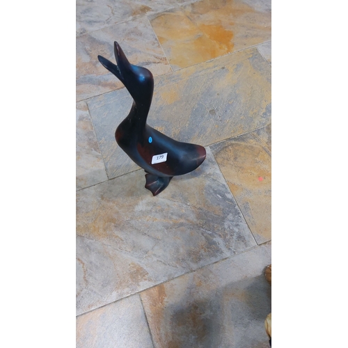 179 - Hand-carved wooden duck figurine. The piece displays a sleek, abstract design, a smooth, polished fi... 