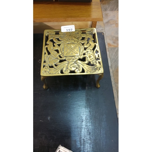 197 - Antique brass trivet with intricate filigree design and coat of arms. Likely late Victorian period.