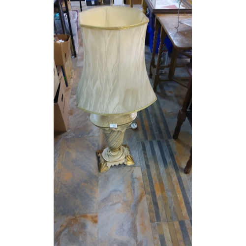 201 - Vintage table lamp with a decorative carved gold-tone base. It features a cream-colored lampshade ad... 