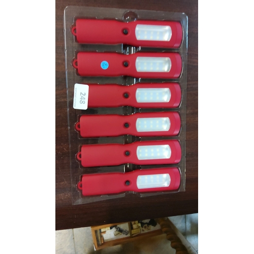 248 - Set of six red handheld LED lights with on/off buttons and hanging loops. Comes in original plastic ... 