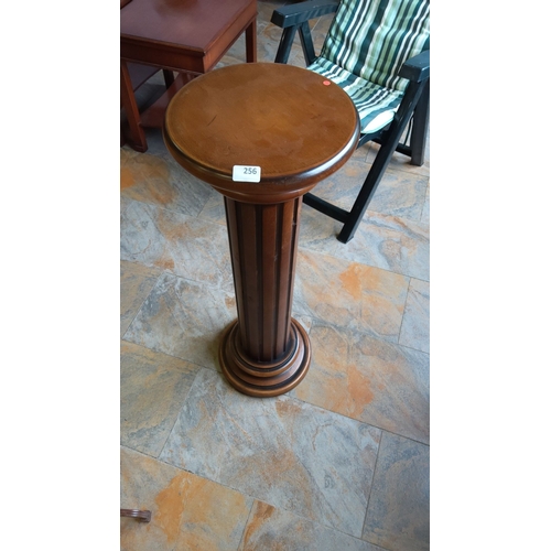 256 - Mahogany pedestal stand featuring a round top and fluted column design.