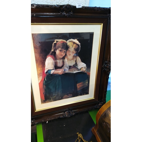 291 - Framed print depicting two young girls reading, surrounded by an ornate dark wood frame with gold in... 