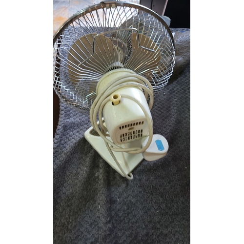 304 - Vintage table fan with metal grill and plastic blades. Features a swing mechanism and adjustable hea... 