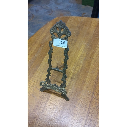 316 - Ornate brass easel stand with intricate scrollwork design. Period unknown.