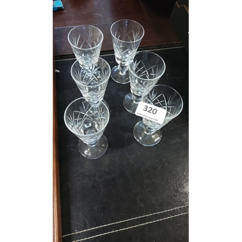 320 - Set of six cut-crystal wine glasses featuring intricate geometric patterns.