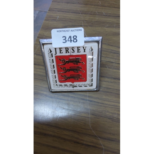 348 - Vintage Badge featuring the coat of arms of Jersey on a red background with a chrome trim.