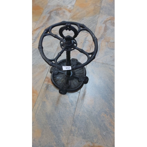 352 - Victorian-style cast iron umbrella stand, intricately designed with a circular base and holder.