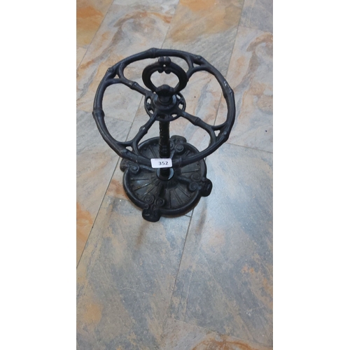 352 - Victorian-style cast iron umbrella stand, intricately designed with a circular base and holder.