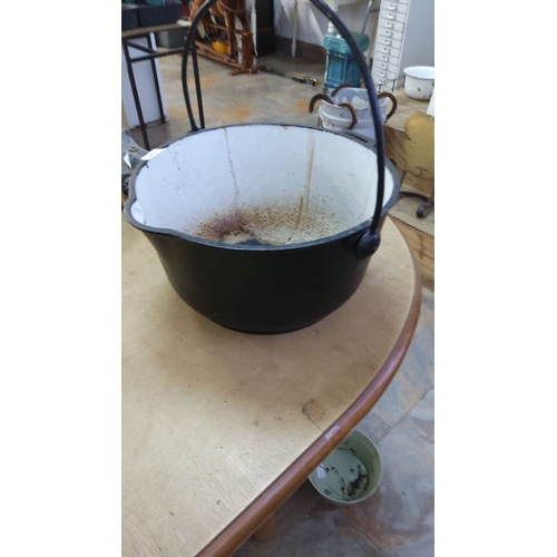 354 - Cast iron cauldron with white enameled interior and black exterior. Features a sturdy swinging handl... 