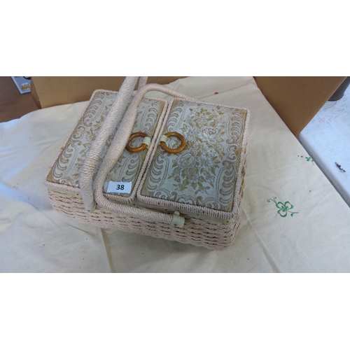 38 - Vintage wicker sewing box with dual handles and embroidered lid panels. The interior features padded... 