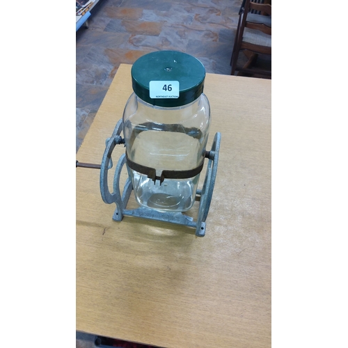 46 - Vintage glass butter churn with metal hand crank mechanism, featuring a green lid and sturdy metal b... 