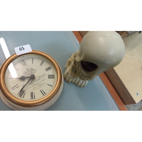 65 - Antique-inspired wall clock with Roman numerals. Includes a decorative skull with large dark eyes.