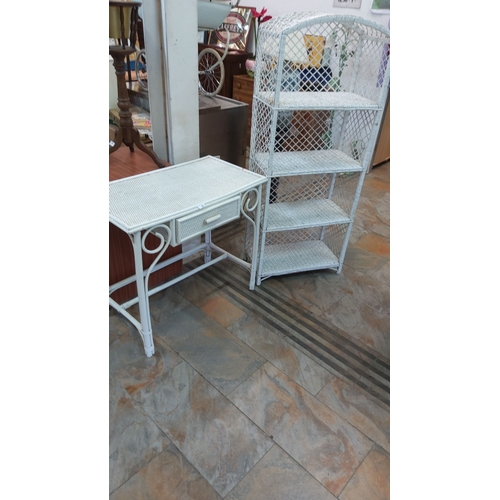 66 - White wicker furniture set including a desk with a drawer and a four-tier shelving unit.