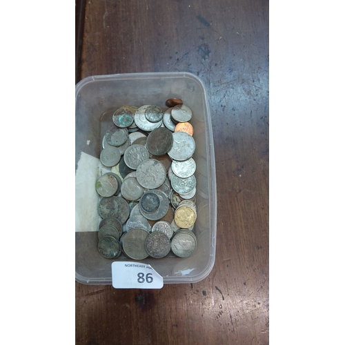 86 - Assorted world coins collection in a plastic container. Various denominations and origins, including... 