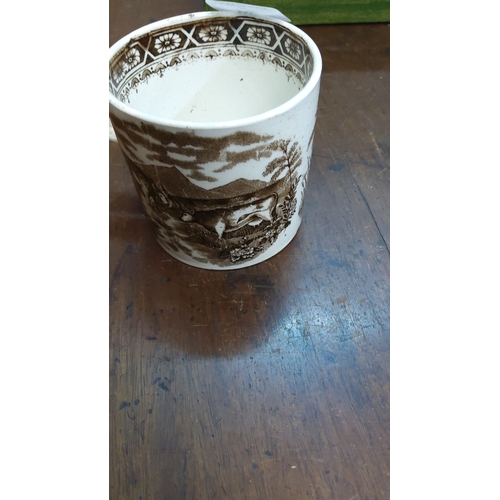 94 - Antique brown transferware mug with a scenic deer hunting motif and floral border detail on the rim.