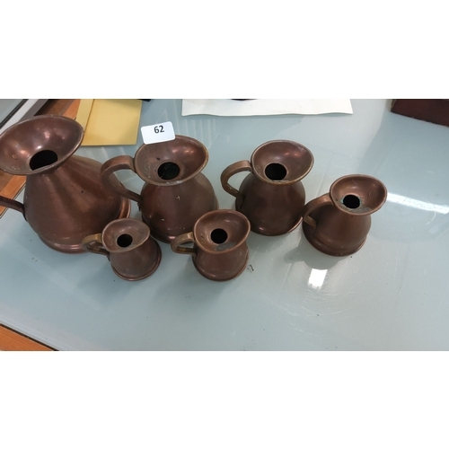 62 - Set of six vintage copper pitchers. The pitchers vary in size, featuring elegant curved handles and ... 