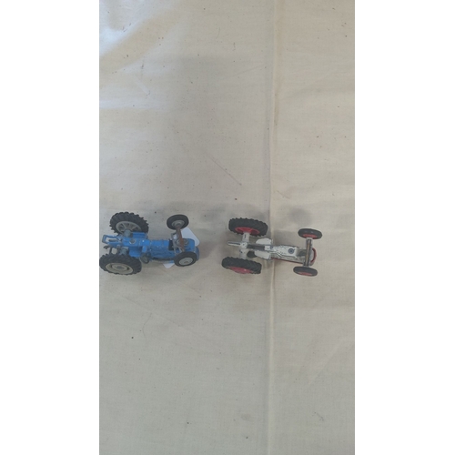 16 - Pair of vintage die-cast toy tractors, one blue and one red. Detailed construction and rubber wheels... 