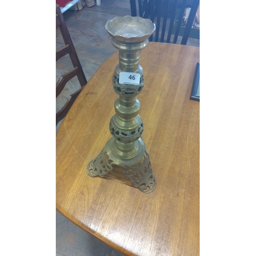 46 - Ornate brass candle holder with intricate cut-out design. This item features a tri-legged base and s... 